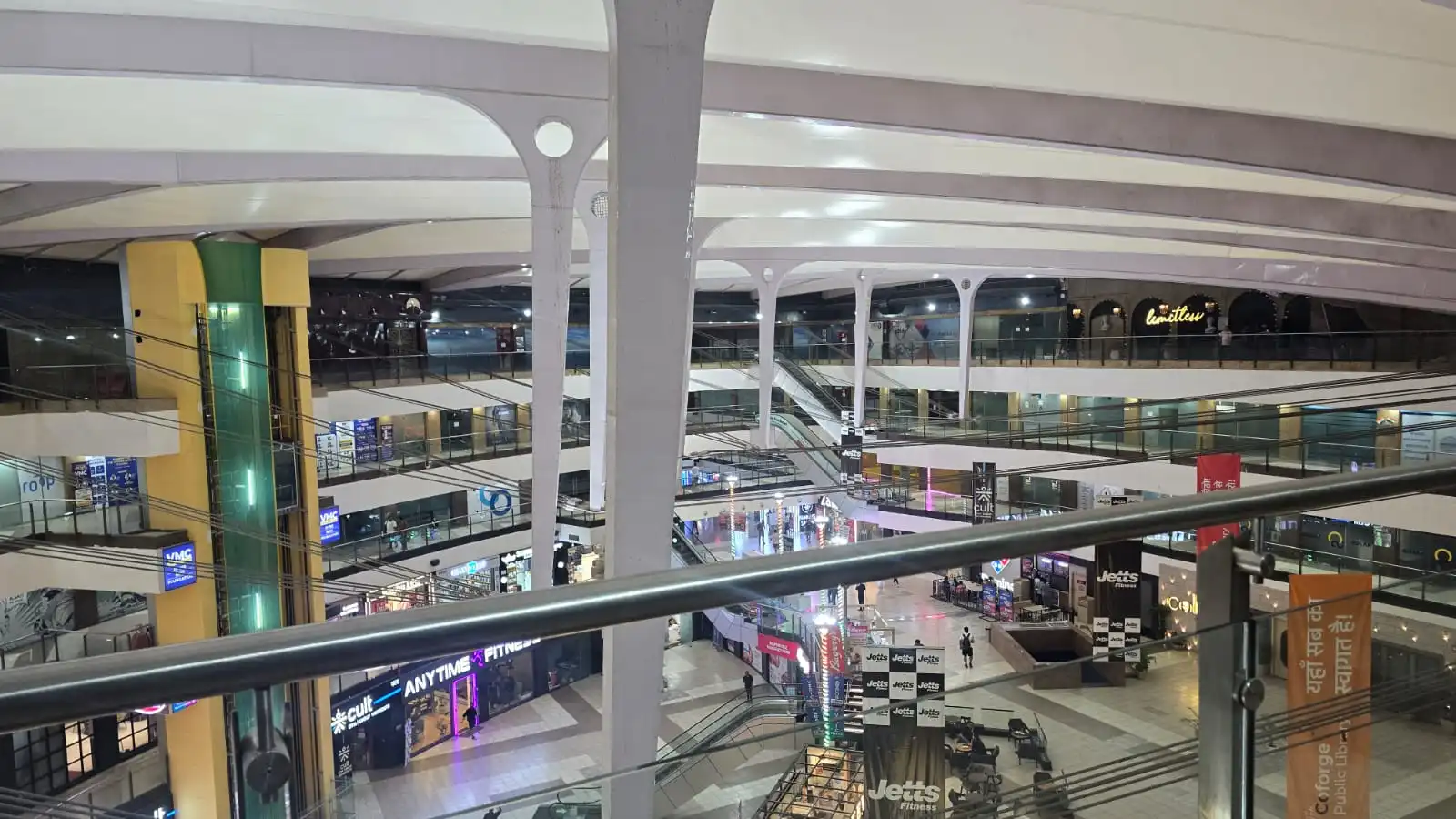 Vasant Square Mall Vasant Kunj — the curved white perimeter edge beam where the tensile membrane meets the fixed roof, on branching steel columns, Ekra Decor